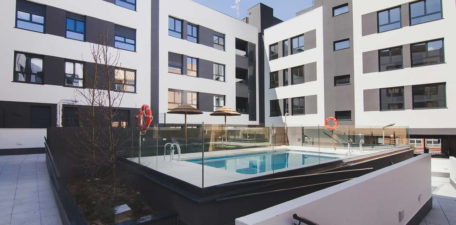 Vista de la piscina y zonas comunes de la promoción de viviendas iKasaClass Puerta de las Rozas