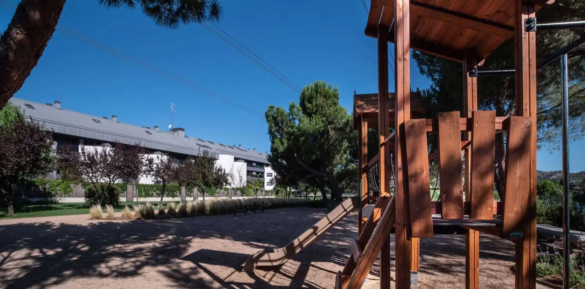 Área infantil con tobogán en el jardín cuidado y con árboles de Lagos Park