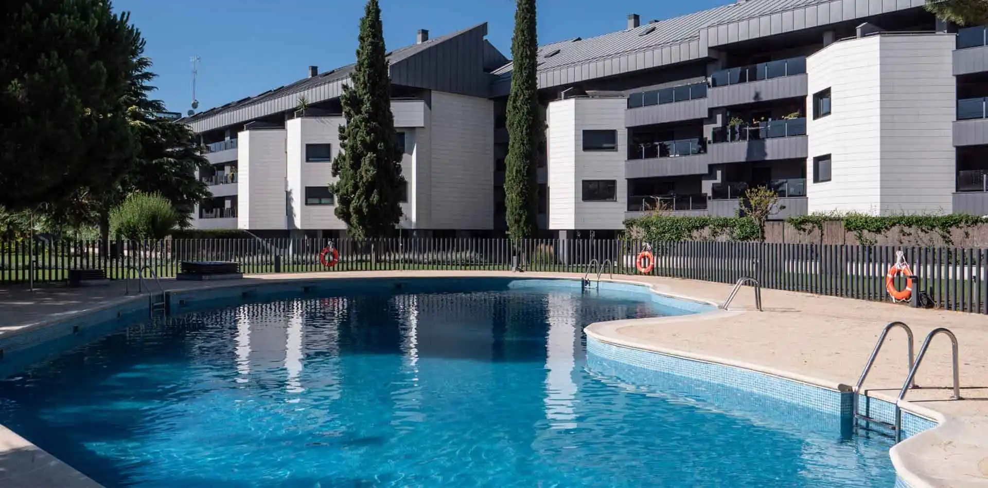Piscina perfecta para refrescarte en verano en Lagos Park con fachada de fondo y viviendas con amplias terrazas.