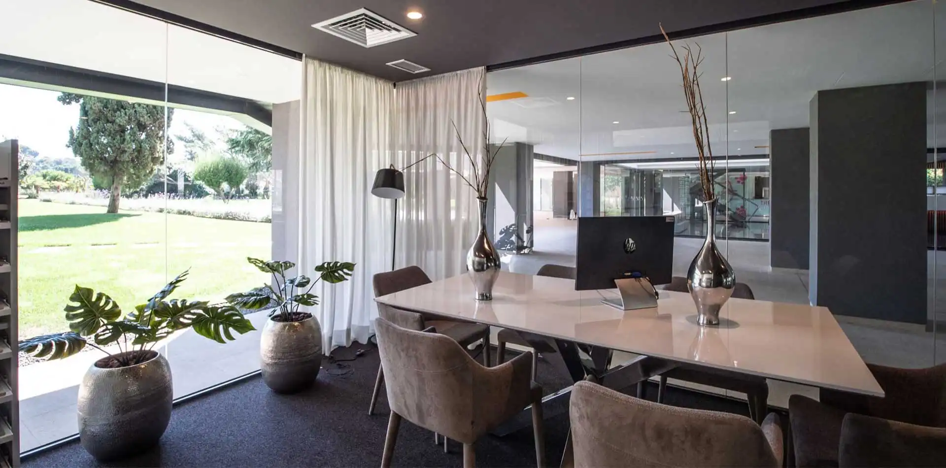 Sala acristalada con mesa de trabajo y vistas al jardín en Lagos Park