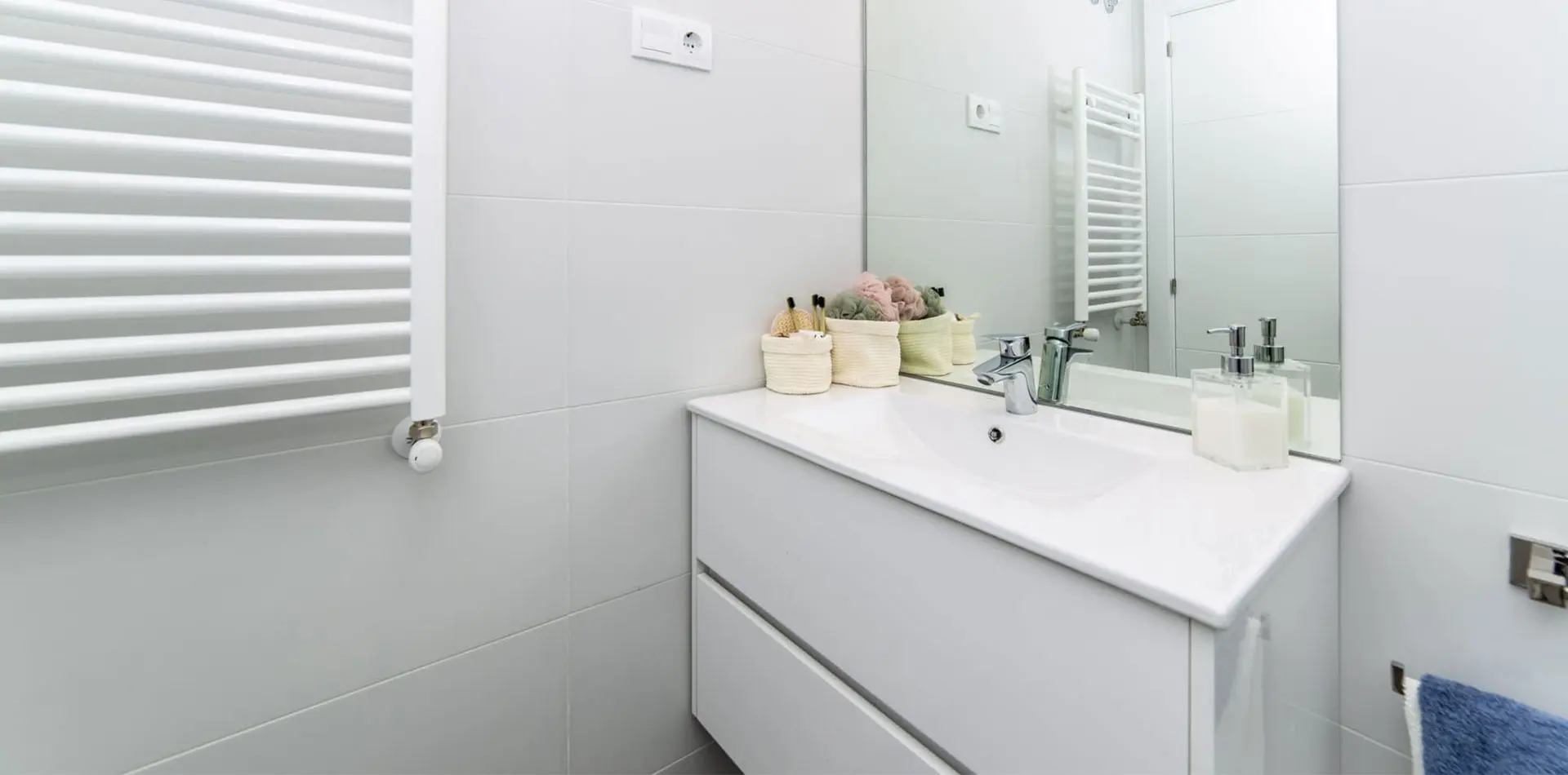 Cuarto de baño con mueble con dos cajones y radiador toallero, todo blanco en Lagos Park
