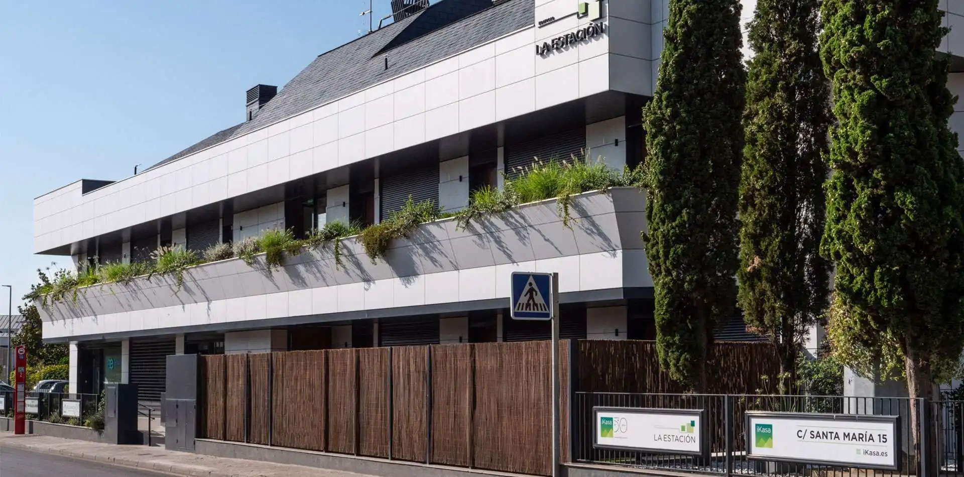 Fachada de edificio La Estación con vegetación en primera planta, en Las Rozas de Madrid.