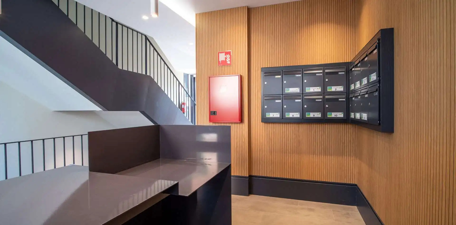 Imagen de la zona de acceso y buzones del Edificio La Estación en Las Rozas de Madrid.