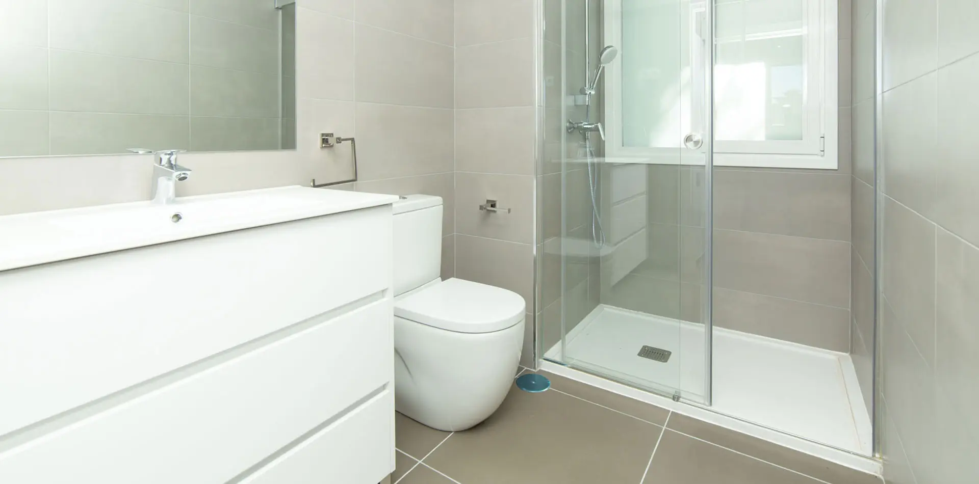 Cuarto de baño con ducha con mámpara y mueble de baño en Edificio La Estación Las Rozas